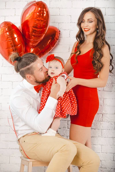 Happy young family mother, father and daughter posing in studio. — Stock Photo, Image