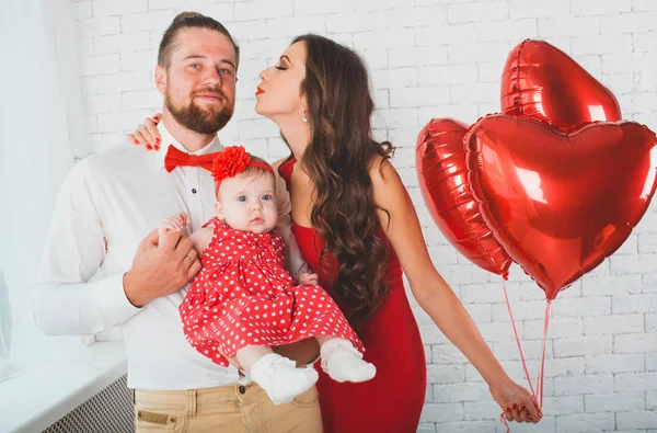 Jovem família feliz mãe, pai e filha posando em estúdio . — Fotografia de Stock