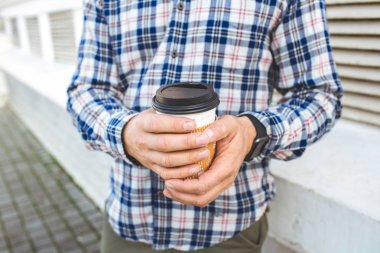 Kahve duvara tutan güneş gözlüğü ile gülümseyen adam