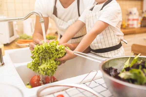 Mannen och pojken tvätta grönsaker innan du äter — Stockfoto