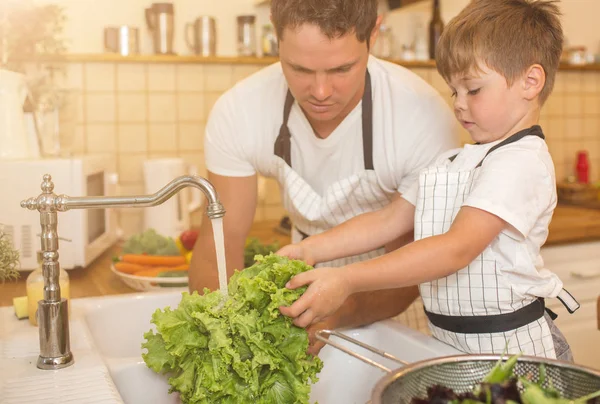 Mannen och pojken tvätta grönsaker innan du äter — Stockfoto