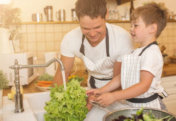 Homem e menino lavando legumes antes de comer — Fotografia de Stock