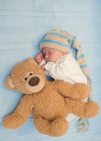 Bebê recém-nascido que estabelece com ursinho de pelúcia no cobertor — Fotografia de Stock