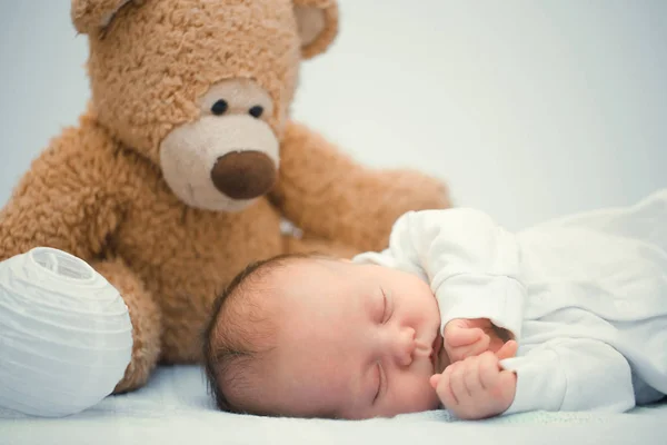 Bebé recién nacido acostado con oso de peluche en la manta — Foto de Stock