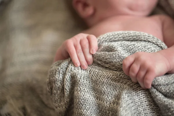 Les mains de l'enfant tiennent une couverture tricotée — Photo