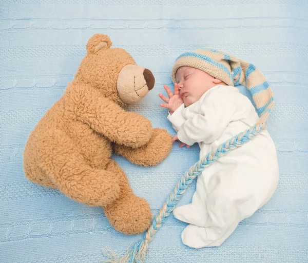 Neugeborenes liegt mit Teddybär auf Decke — Stockfoto