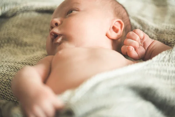 The child's hands hold a knitted blanket — Stock Photo, Image