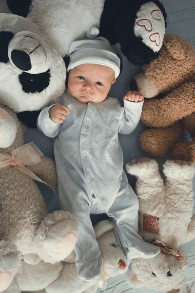 Neugeborenes liegt mit fünf Teddybären auf Decke — Stockfoto