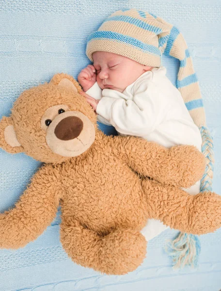 Bebé recién nacido acostado con oso de peluche en la manta —  Fotos de Stock