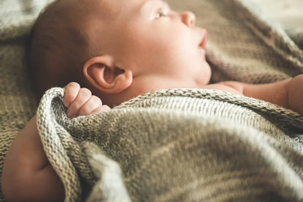 The child's hands hold a knitted blanket — Stock Photo, Image