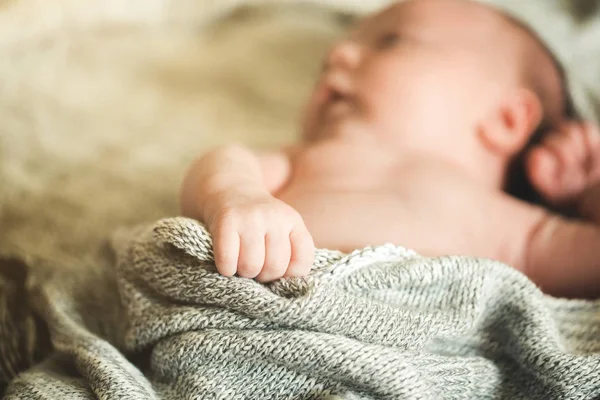 The child's hands hold a knitted blanket — Stock Photo, Image