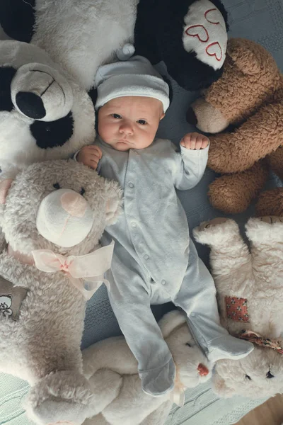 Neugeborenes liegt mit fünf Teddybären auf Decke — Stockfoto