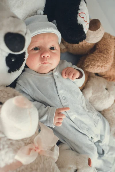 Bebé recién nacido acostado con cinco osos de peluche en la manta — Foto de Stock