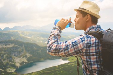 Genç bir gezgin, Rila Dağları su içer. Bulgaristan'da seyahat