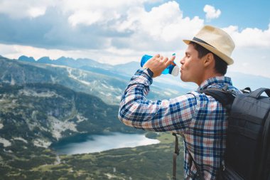 Genç bir gezgin, Rila Dağları su içer. Bulgaristan'da seyahat