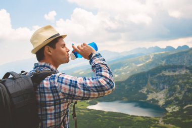Genç bir gezgin, Rila Dağları su içer. Bulgaristan'da seyahat