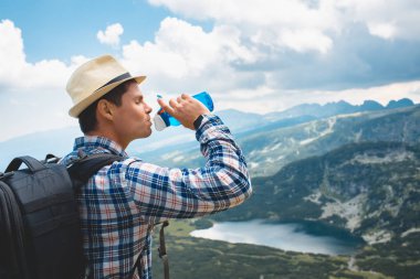 Genç bir gezgin, Rila Dağları su içer. Bulgaristan'da seyahat
