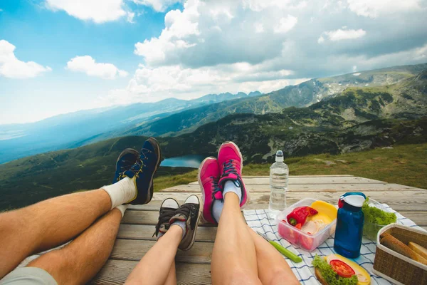 坐在高高的山上的木台上的旅行家的腿 自由概念 野餐在自然 Rila 山在保加利亚 — 图库照片