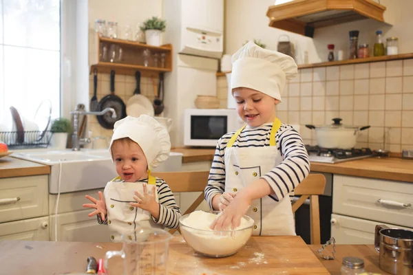 Two little brothers in chef's hats are cooking — Stock Photo, Image