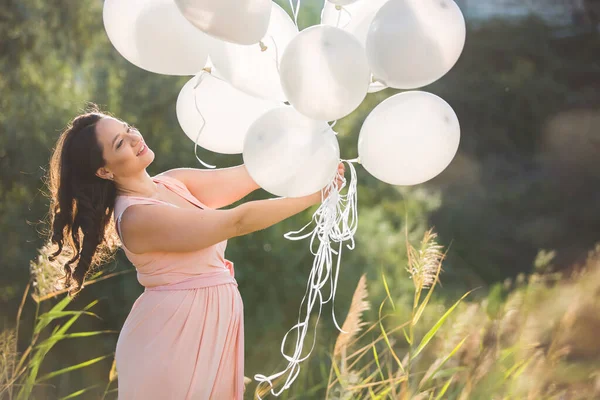 Plus storlek modell poserar med vita ballonger. — Stockfoto