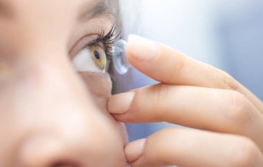 Genç kız kontakt lens takıyor.