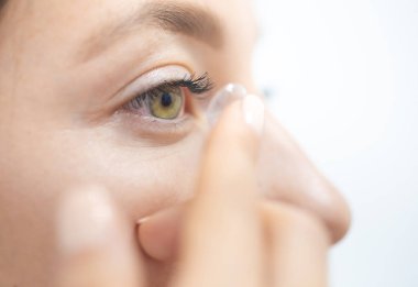 Genç kız kontakt lens takıyor.