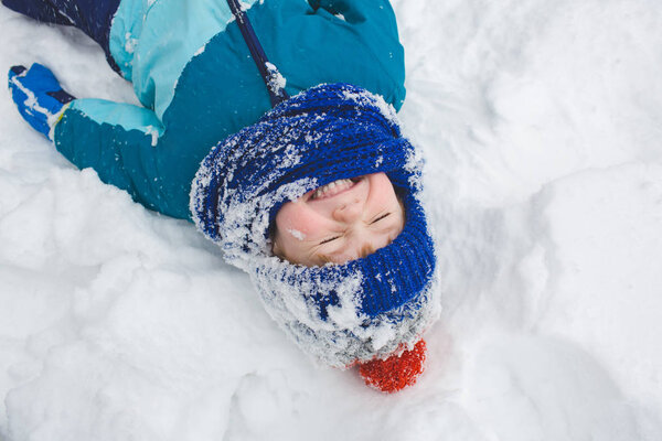 Little boy lies in the snow