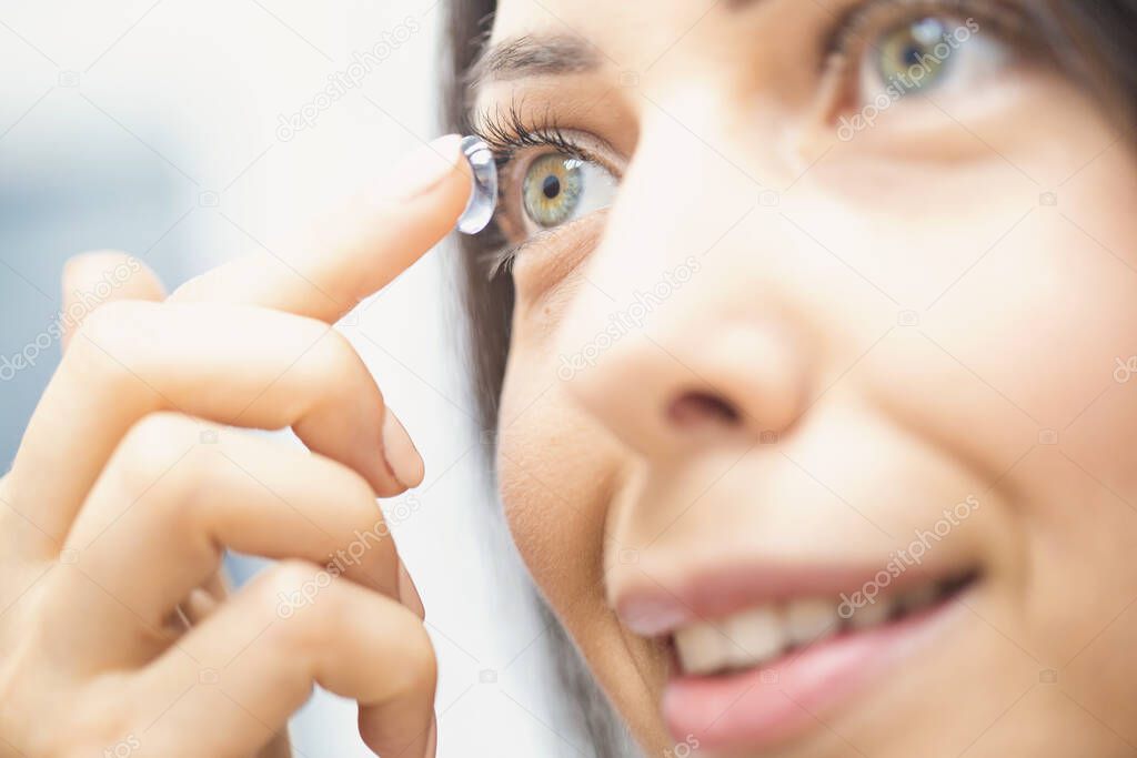 Young girl puts on contact lenses
