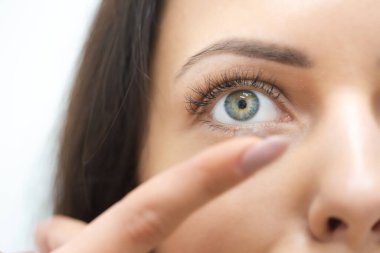 Genç kız kontakt lens takıyor.