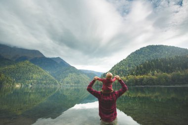 Dad and son walk by the lake