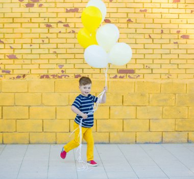 Little boy posing against the wall