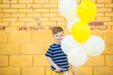 Little boy posing against the wall