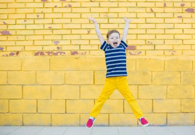 Little boy posing against the wall