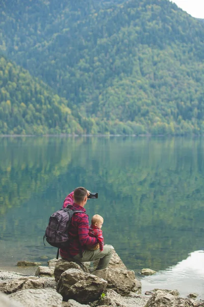 Papa en zoon lopen bij het meer. — Stockfoto