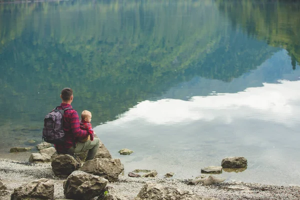 Táta a syn se procházejí kolem jezera — Stock fotografie