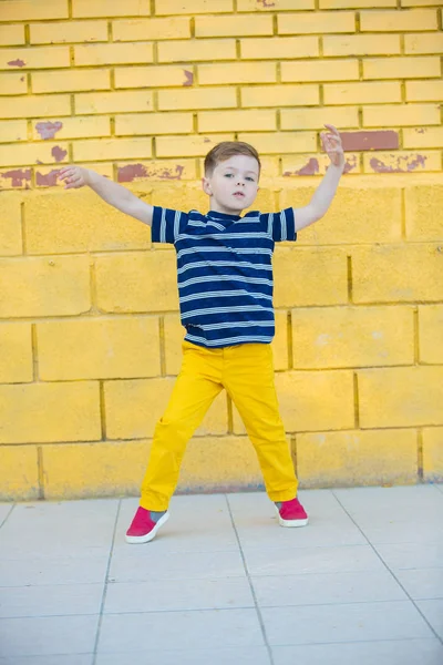 Kleiner Junge posiert gegen die Wand — Stockfoto