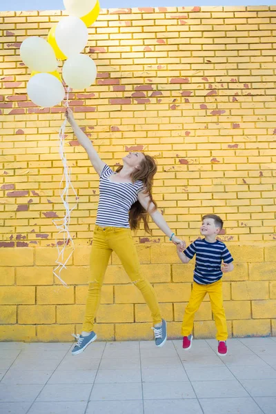 Piccolo ragazzo e la sua mamma posa contro il muro — Foto Stock