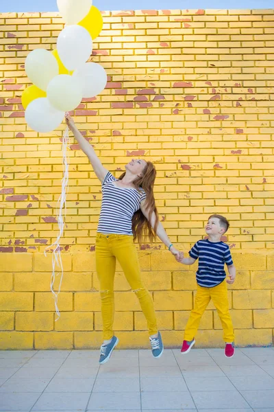 Piccolo ragazzo e la sua mamma posa contro il muro — Foto Stock