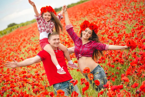 Pregnant woman her husband and their daughter in poppy field — Stok fotoğraf
