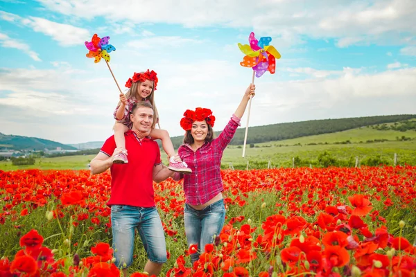 Schwangere Frau, ihr Mann und ihre Tochter im Mohnfeld — Stockfoto