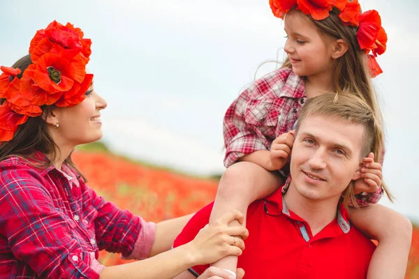 Pregnant woman her husband and their daughter in poppy field — 스톡 사진