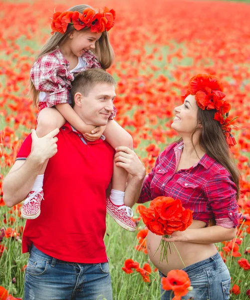 Pregnant woman her husband and their daughter in poppy field — ストック写真