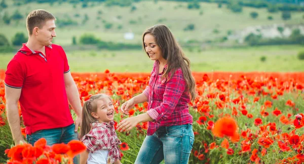 Женщина ее муж и их дочь в маковом поле — стоковое фото