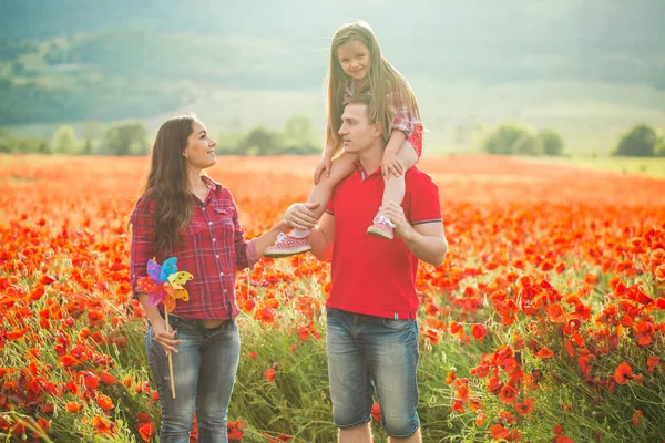 Schwangere Frau, ihr Mann und ihre Tochter im Mohnfeld — Stockfoto