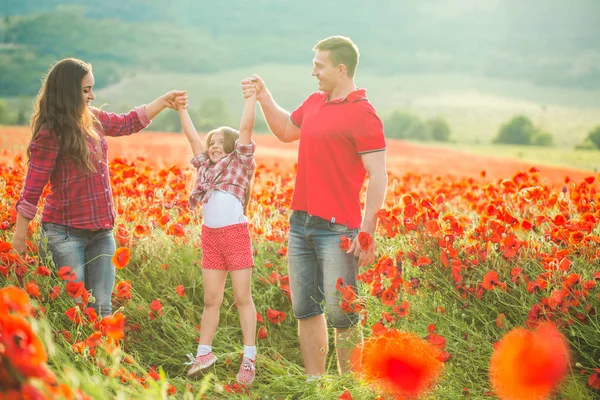 Pregnant woman her husband and their daughter in poppy field — 스톡 사진