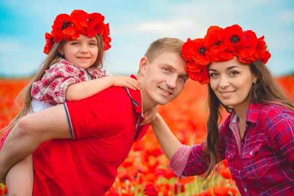 Schwangere Frau, ihr Mann und ihre Tochter im Mohnfeld — Stockfoto