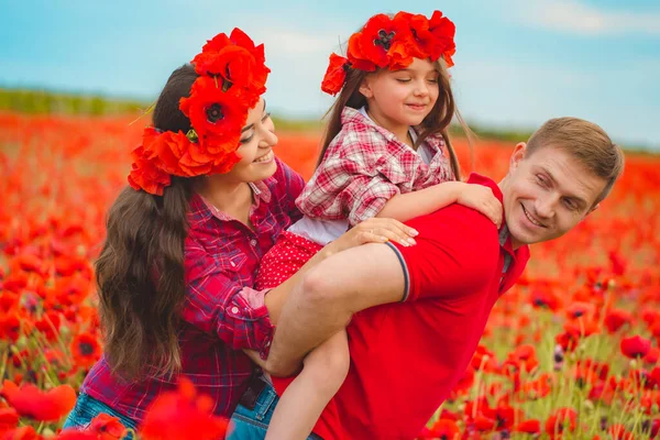 Donna incinta suo marito e la loro figlia nel campo di papavero — Foto Stock