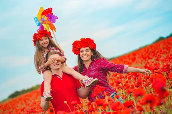 Zwangere vrouw haar man en hun dochter in papaverveld — Stockfoto