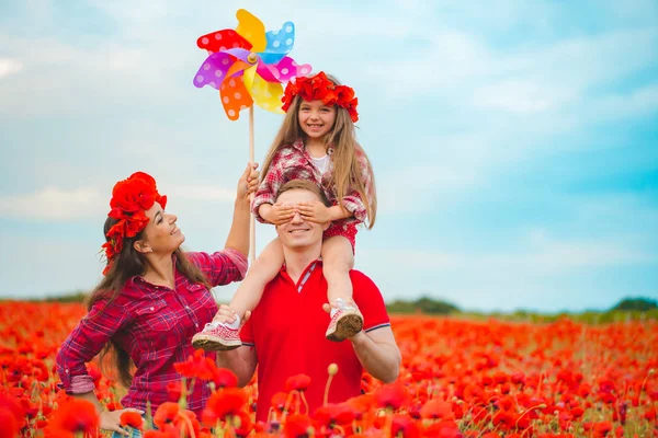 Zwangere vrouw haar man en hun dochter in papaverveld — Stockfoto