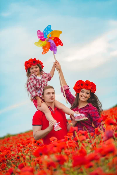 Pregnant woman her husband and their daughter in poppy field — ストック写真